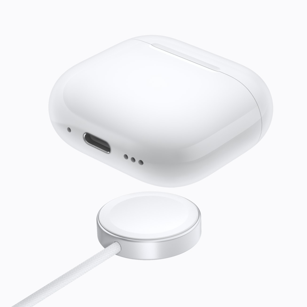 充電器の上に置かれたワイヤレス充電ケース付きAirPods 5のApple公式写真